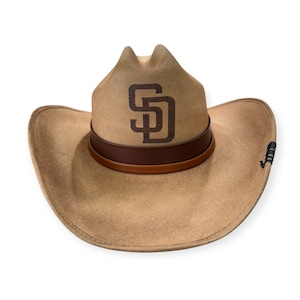 Könnte beinhalten: Ein beiger Cowboyhut mit einem braunen Lederband und einem braunen "SD"-Logo auf der Vorderseite.