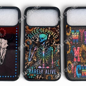 May include: Three black phone cases with unique designs. One features a bull skull, another a skeleton with the text "Sleep Deprived" and "Barely Alive", and the third says "Wife Mom Nurse".