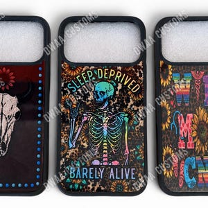 May include: Three black phone cases with unique designs. One features a bull skull, another a skeleton with the text "Sleep Deprived" and "Barely Alive", and the third says "Wife Mom Nurse".