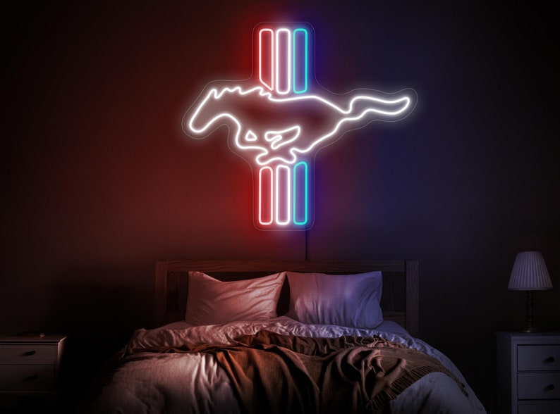 May include: A white neon sign with a running horse silhouette and three vertical bars. The bars are red, white, and blue. The sign is mounted on a dark wall above a bed with brown bedding.