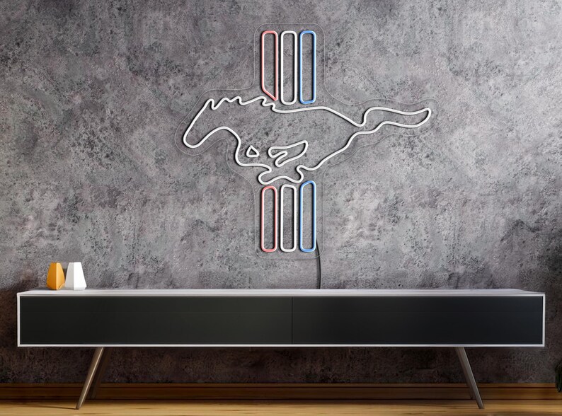 May include: A white neon sign of a running horse with a red, white, and blue vertical stripe design. The sign is mounted on a gray concrete wall above a black entertainment console.