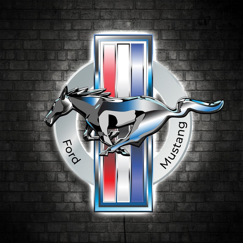 May include: A silver Ford Mustang logo with a black horse running to the right. The logo is on a brick wall background with a white circle around the horse and a blue, white, and red rectangle behind the horse. The words "Ford" and "Mustang" are written on the circle.
