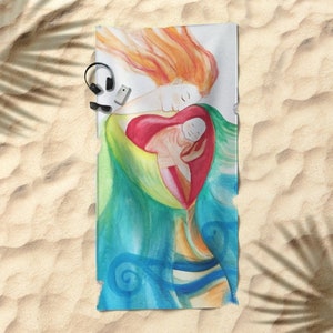 May include: Beach towel featuring a watercolor illustration of a mother and child embraced within a heart shape. The artwork uses a palette of red, green, blue, and orange. The towel is rectangular and rests on a sandy surface.
