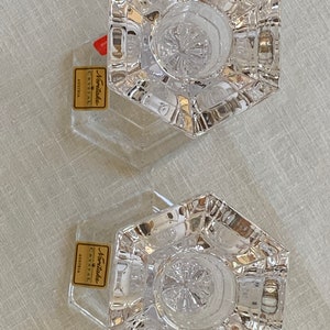 K&ouml;nnte beinhalten: Zwei klare Glaskerzenhalter mit sechseckiger Basis und einem Sternmuster. Die Halter werden von Noritake Crystal Austria hergestellt.