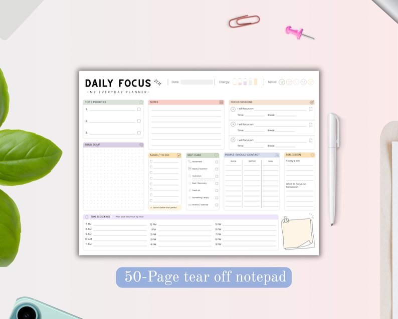 May include: A rectangular daily planner notepad with the text DAILY FOCUS and MY EVERYDAY PLANNER. The layout includes sections for top priorities, notes, focus sessions, brain dump, tasks, self-care, contacts, reflection, and time blocking.