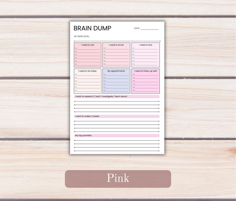 May include: A white paper planner page titled BRAIN DUMP with a date line and main goal section. It features six rectangular boxes in pink and light blue for tasks, plus lined sections for research, creation, and top priorities.