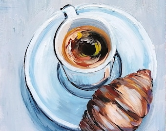 May include: A white cup of coffee with a brown croissant on a white saucer. The coffee is dark brown and the croissant is flaky and golden brown.