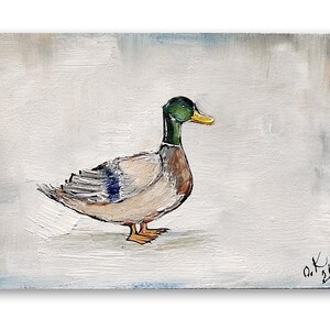 May include: A painting of a mallard duck with a green head and yellow beak on a white background. The duck is facing to the right and has its wings folded. The artist's signature is in the bottom right corner of the painting . Mallard duck painting original miniature art Vintage duck oil painting farmhouse kitchen wall art country decor duck hunting gift 4x6
