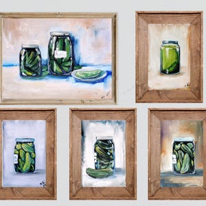 May include: A collection of five framed art pieces featuring still-life paintings of jars filled with pickles. The paintings showcase the pickles in a variety of compositions, with wooden frames and a neutral background.