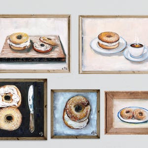 May include: A collection of five framed paintings depicting bagels. The paintings feature bagels with cream cheese, a knife, and a cup of coffee. The artwork is in a rustic style with a neutral color palette, perfect for kitchen or dining room decor.
