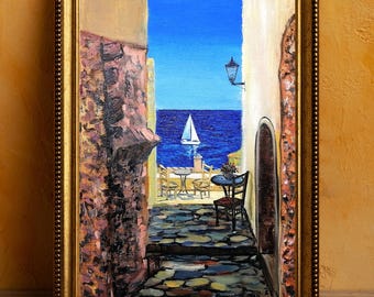 May include: A painting of a narrow street with a view of the ocean and a sailboat. The street is lined with buildings and there are tables and chairs set up outside. The painting is done in a realistic style with vibrant colors.
