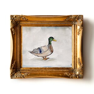 May include: A painting of a mallard duck in a gold frame. The duck is facing to the right and has a green head and a yellow beak. The duck is painted on a white background. Mallard duck painting original miniature art Vintage duck oil painting farmhouse kitchen wall art country decor duck hunting gift 4x6