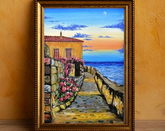 May include: A painting of a stone pathway leading to a small house with a red tile roof. The house is surrounded by lush greenery and flowers. The pathway leads to a body of water with a blue sky and a crescent moon in the background.