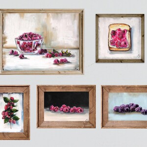 May include: A collection of framed art prints featuring still life paintings of raspberries. The artwork includes a bowl of raspberries, a slice of toast with jam, and close-ups of the fruit. The paintings are in wooden frames.