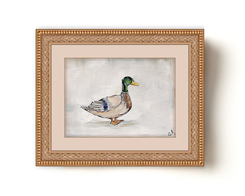 May include: A framed painting of a mallard duck with a green head and brown and white feathers. The duck is standing on a white background. The painting is in a gold frame with a decorative border. The artist's signature is in the bottom right corner of the painting. Mallard duck painting original miniature art Vintage duck oil painting farmhouse kitchen wall art country decor duck hunting gift 4x6