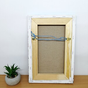 May include: The back of a framed canvas painting with a wooden frame. The canvas is stapled to the frame and has a blue string attached to two metal hooks on the back of the frame. Greece wall art oil painting Canvas Santorini greece art Greek island oil painting