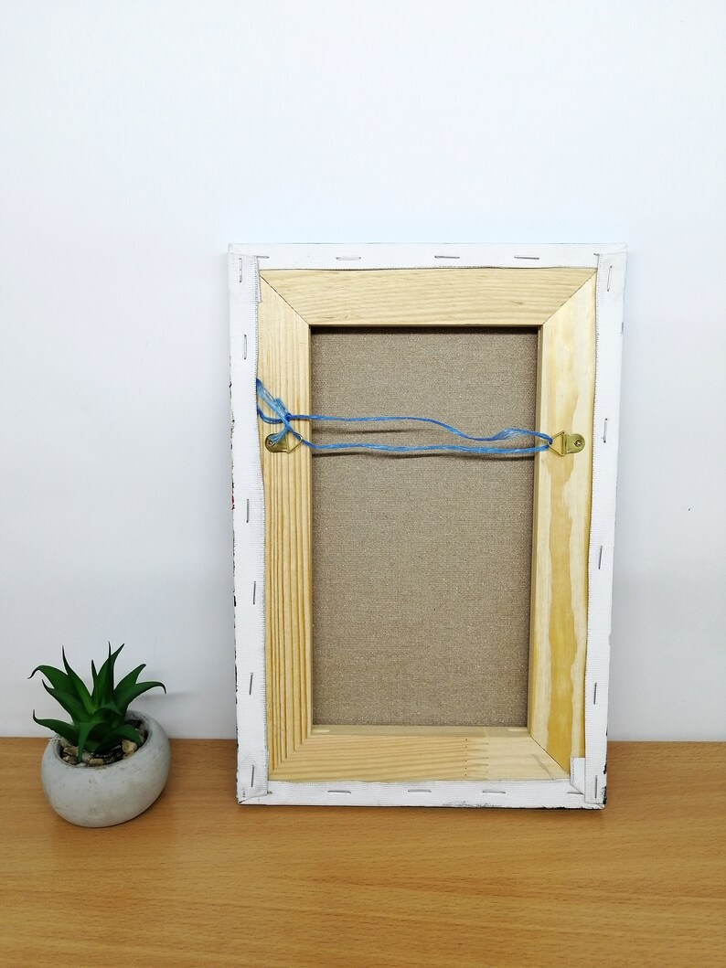 May include: The back of a framed canvas painting with a wooden frame. The canvas is stapled to the frame and has a blue string attached to two metal hooks on the back of the frame. Greece wall art oil painting Canvas Santorini greece art Greek island oil painting