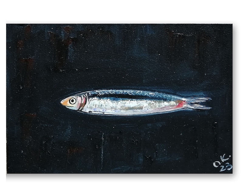 May include: A painting of a silver fish with a red stripe on a black background. The fish is swimming to the right. The artist's initials 'O.K.' and the year '23' are in the bottom right corner of the painting. Sardine art original painting Sardines still life oil painting miniature Anchovy fish painting French country kitchen art 4x6