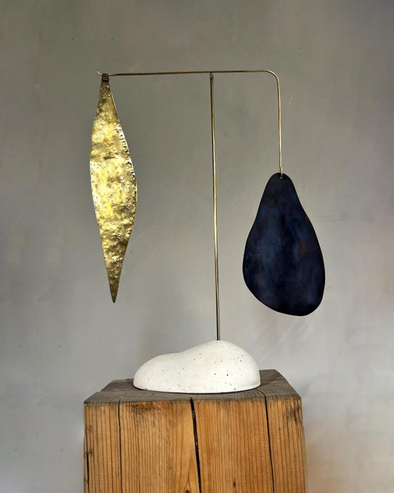 A handcrafted brass tabletop standing mobile — 62 favorites back up its mid-century modern appeal as a genuinely artisan kinetic sculpture that feels like a gallery piece.