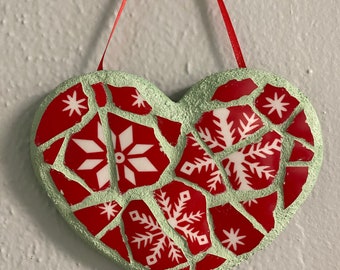 Heart shaped mosaic with red snowflake pattern. Red ribbon for hanging.