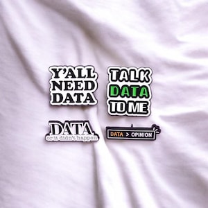 May include: Four black and white iron-on patches with green and orange text. The patches say "Y'all Need Data", "Talk Data To Me", "Data or it didn't happen", and "Data > Opinion".