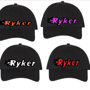 May include: Four black baseball caps with a flame design and the word "Ryker" in different colors. The colors are orange, pink, white, and red.