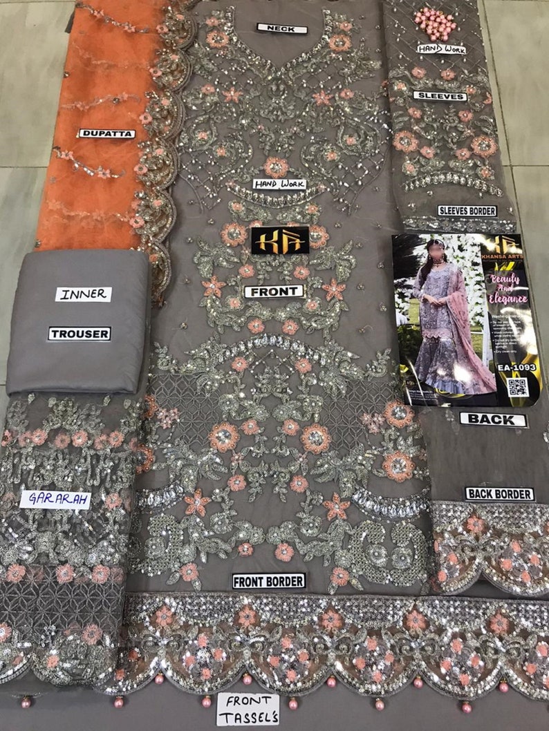 以下が含まれることがあります： グレーの刺繍が施されたフォーマルな衣装で、複雑な花柄とスパンコールのディテールが特徴です。 セットには、デュパッタ、インナーライニング、ズボン、そして「手作業」と「袖」の詳細が記載された「フロント」とラベル付けされた衣服が含まれています。 デザインは、タッセル付きのスカラップボーダーが特徴です。