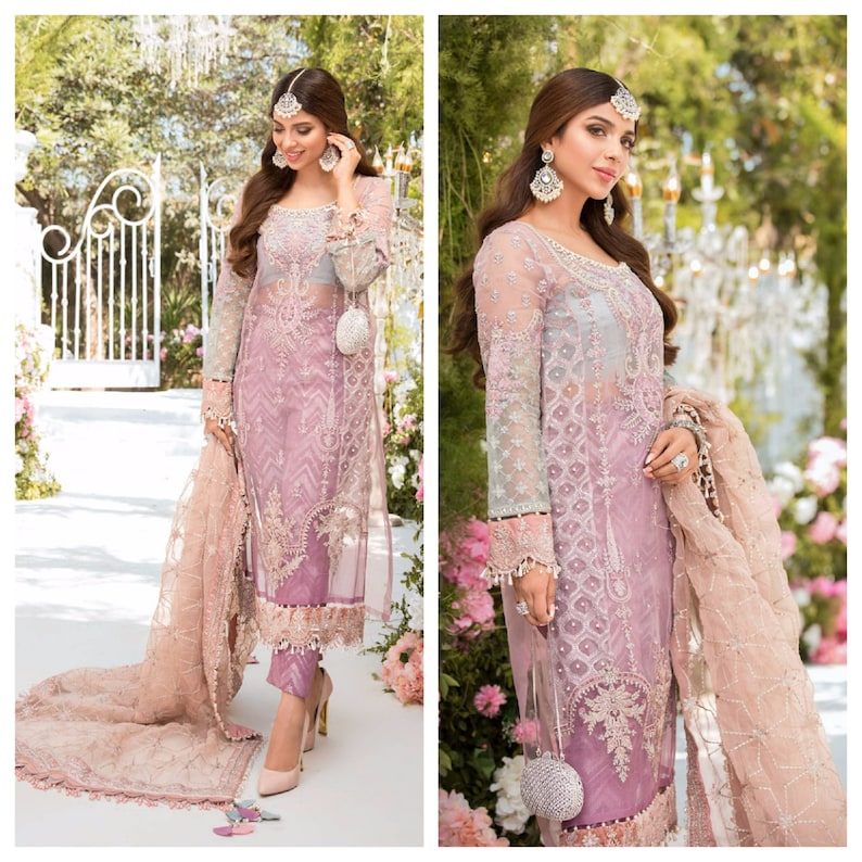 May include: A formal lavender dress with intricate embroidery and sheer sleeves. The dress features a matching scarf and is paired with high heels. The outfit is accessorized with a small, beaded purse and headpiece, creating an elegant ensemble.