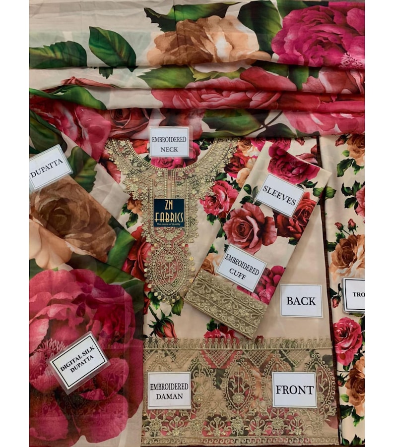 Puede incluir: Un conjunto de tela beige con un estampado floral de rosas en tonos rosa y rojo. El conjunto incluye una parte superior con detalles bordados, mangas y una dupatta de seda digital. El texto "ZN FABRICS" es visible.