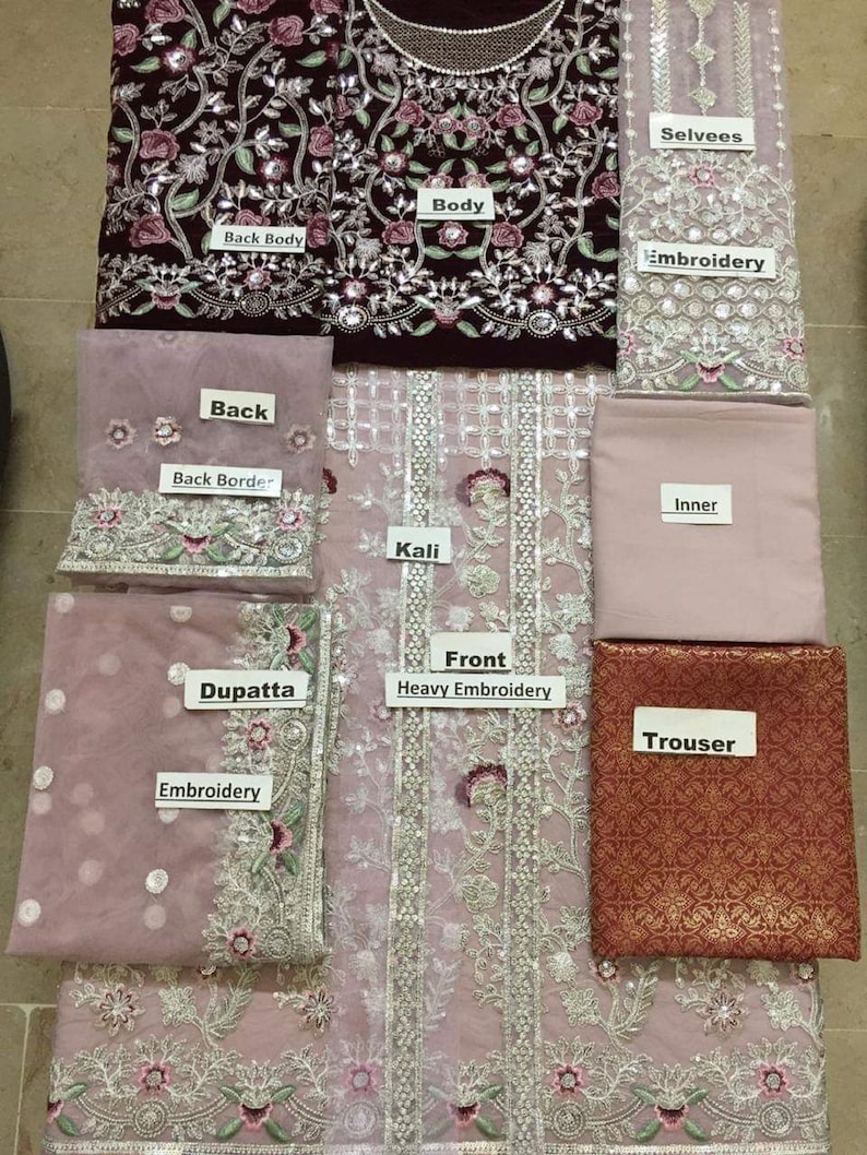 Op de afbeelding: Een meerdelige geborduurde kleding set in tinten bordeauxrood en roze. De set bevat een body, rug, mouwen, dupatta en broek. De stukken hebben ingewikkelde bloemenborduurwerk en versieringen.