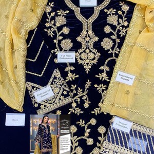 May include: Navy blue velvet embroidered outfit with gold floral detailing. Includes an embroidered dupatta and trouser embroidery. The outfit features text labels: "Full Front Embroidered", "Embroidered Sleeves", "Embroidered Back Daman", and "Front Daman Embroidered".
