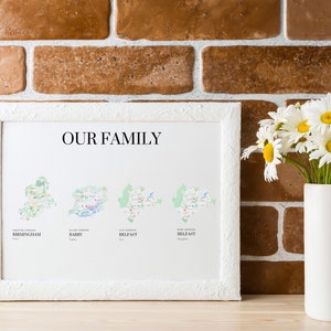 Könnte beinhalten: Ein weißer gerahmter Druck mit dem Text "OUR FAMILY" oben. Der Druck zeigt vier Karten verschiedener Städte: Birmingham, Barry, Belfast und Belfast. Der Druck wird an einer Backsteinwand mit einer Vase voller weißer Gänseblümchen im Vordergrund gezeigt.
