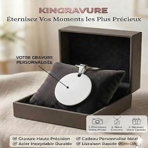 Può includere: Un portachiavi rotondo color argento è appoggiato su un cuscino di velluto grigio scuro all'interno di una scatola marrone aperta. Il testo nell'immagine recita "KINGRAVURE" e "YOUR PERSONALIZED ENGRAVING". Il portachiavi è pronto per l'incisione.