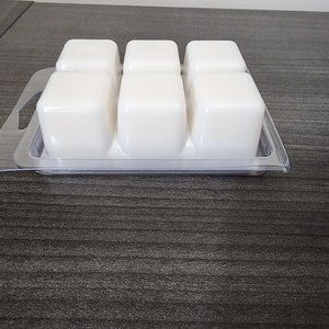 Peut inclure: Un plateau en plastique transparent avec six cubes de cire blanche dispos&eacute;s en grille. Le plateau a une poign&eacute;e de chaque c&ocirc;t&eacute;.