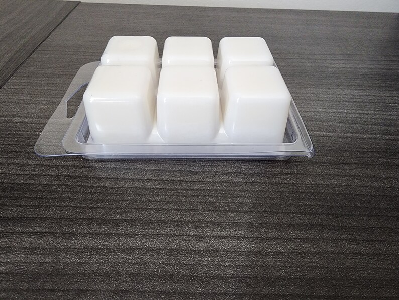 Peut inclure: Un plateau en plastique transparent avec six cubes de cire blanche dispos&eacute;s en grille. Le plateau a une poign&eacute;e de chaque c&ocirc;t&eacute;.