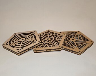 Könnte beinhalten: Drei lasergeschnittene Untersetzer aus Holz mit aufwendigen Designs. Einer hat ein fächerartiges Muster, ein anderer ein Zahnraddesign und der dritte einen geometrischen Stern. Die Untersetzer sind aus hellem Holz gefertigt.