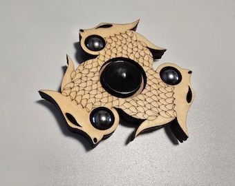 Spinner antiestrés con forma de dragón, de madera grabada con láser y con bolas de acero.