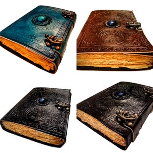 May include: Four leather-bound journals with intricate designs and gemstone accents. Each journal features a different color and design, including blue, brown, black, and a combination of black and blue.