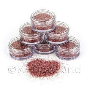 Könnte beinhalten: Sechs kleine, transparente Gläser gefüllt mit roségoldfarbenem Glitter, in Pyramidenform gestapelt. Der Glitter ist vor den Gläsern ausgekippt.
