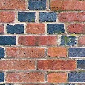Peut inclure: Un mur de briques avec des briques rouges et bleu foncé alternées. Les briques sont disposées en quinconce, créant une surface texturée.