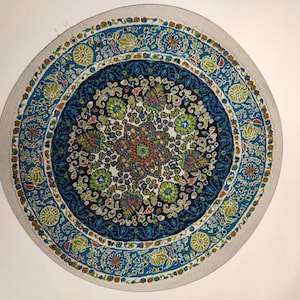 Könnte beinhalten: Ein runder Teppich mit einem blauen, grünen und weißen Blumenmuster. Der Teppich hat einen weißen Rand mit einem sich wiederholenden Muster aus Blumen und Blättern.