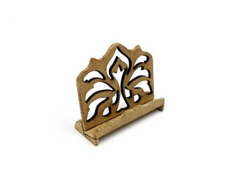 May include: A wooden music stand with a decorative cutout design in the shape of a stylized flower. The stand is made of light brown wood and has a simple, elegant design.