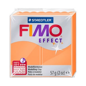 May include: Orange FIMO Effect modeling clay in a clear plastic package. The package features the STAEDTLER logo and the FIMO Effect brand name in red, orange, and purple. The package contains 2 oz of clay and instructions for oven-baking at 230°F for 30 minutes.