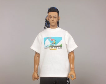 Puede incluir: Camiseta blanca con un estampado gráfico de un personaje de dibujos animados de la película "Ponyo en el acantilado junto al mar". La camiseta tiene el texto "PONYO ON THE CLIFF" y caracteres japoneses. El modelo lleva pantalones negros con una raya blanca a cuadros en el lateral y zapatillas marrones y blancas.