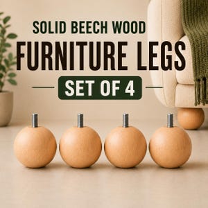 May include: A set of four spherical solid beech wood furniture legs, each featuring a metal threaded bolt at the top. The text SOLID BEECH WOOD FURNITURE LEGS SET OF 4 is displayed in dark green lettering above the wooden spheres.