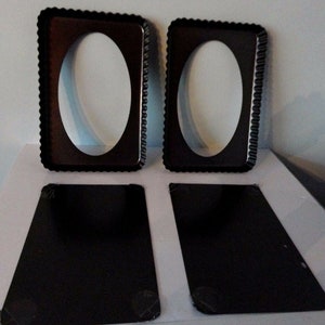 May include: Two black metal tart pans with fluted edges and a removable bottom. The pans are designed for baking oval-shaped tarts. Two additional black metal baking sheets are also included.
