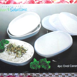 May include: A product box featuring white oval ceramic ramekins with clear plastic lids. The ramekins are filled with rice and garnished with green broccoli and black sesame seeds. The box reads "Always Home Kitchen Solutions."