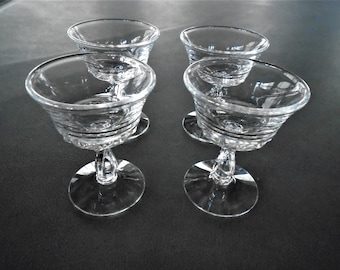 May include: Four clear glass stemmed dessert dishes with a fluted design.