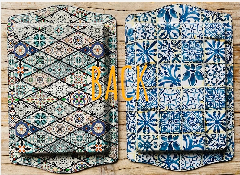 May include: Two rectangular serving trays with a decorative tile pattern. The tray on the left has a blue, green, and white pattern. The tray on the right has a blue and white pattern. The word "BACK" is written in orange letters on the image.