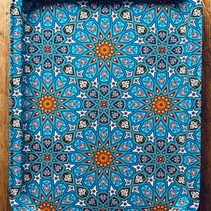 May include: A blue and gold tray with a geometric pattern. The tray has a rounded edge and is made of metal.